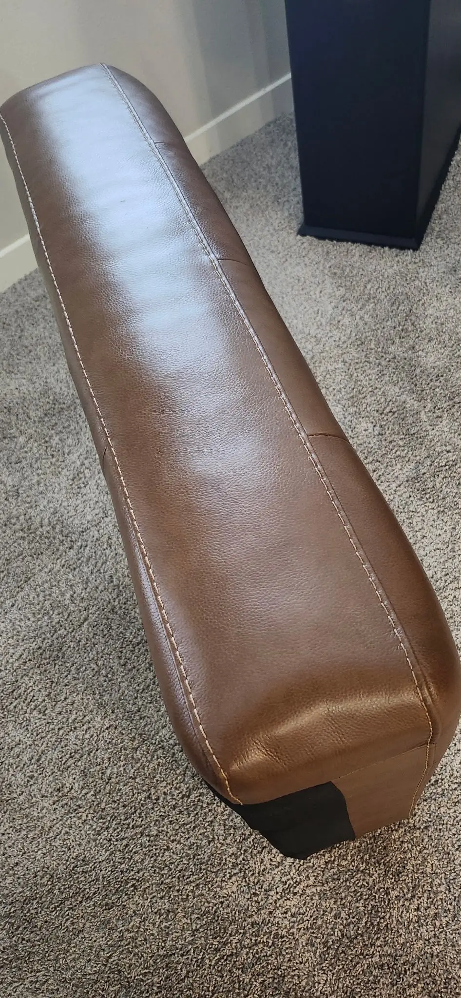 A richly recoloured brown leather cushion, smooth and conditioned